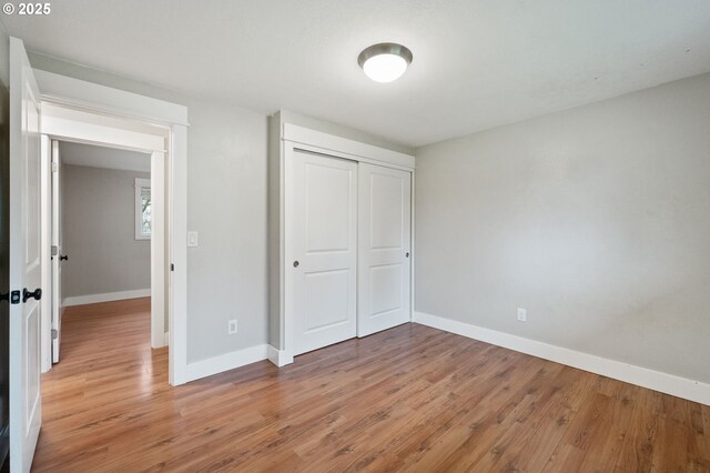 unfurnished bedroom with a closet and light hardwood / wood-style flooring