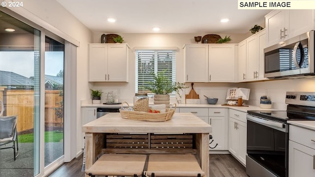 kitchen with recessed lighting, white cabinets, light countertops, appliances with stainless steel finishes, and dark wood finished floors