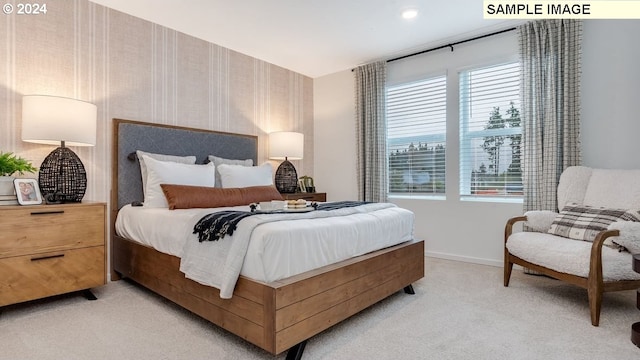 bedroom with baseboards, light colored carpet, and wallpapered walls