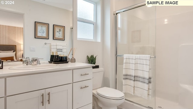 full bathroom featuring toilet, a stall shower, and vanity