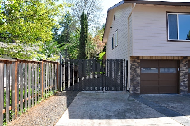 13950 SW Barlow Rd, Beaverton, OR 97008 - view of home's exterior with stone siding, a garage, driveway, and a gate
