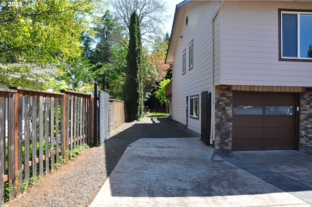 13950 SW Barlow Rd, Beaverton, OR 97008 - view of home's exterior featuring stone siding, a garage, and concrete driveway