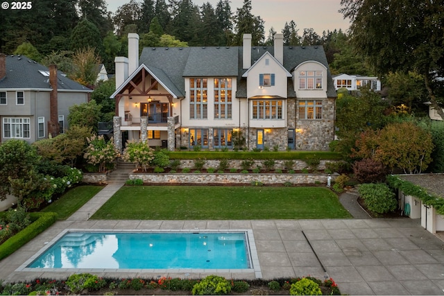 11859 S Riverwood Rd, Portland, OR 97219 - rear view of house with a balcony, stone siding, a lawn, stucco siding, and a chimney