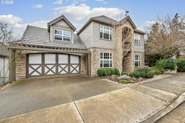 view of front of house featuring a garage, stone siding, and concrete driveway