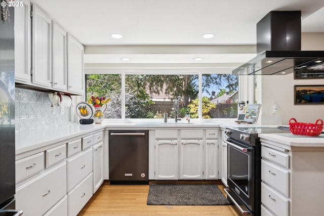 11820 SW Reid Ct, Beaverton, OR 97008 - kitchen featuring appliances with stainless steel finishes, range hood, light countertops, light wood-style flooring, and a sink