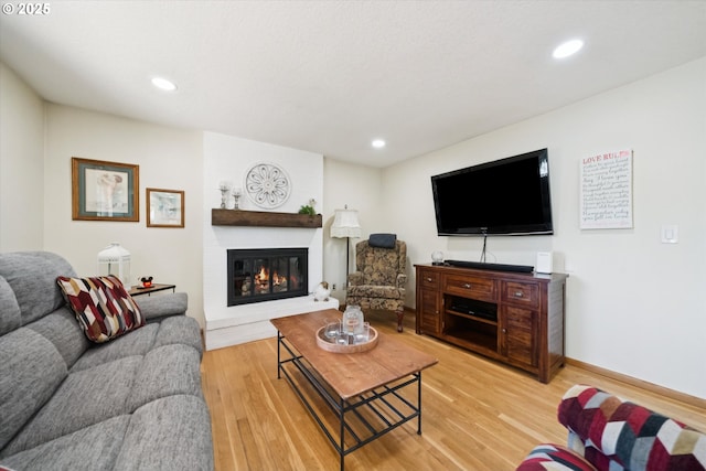 11820 SW Reid Ct, Beaverton, OR 97008 - living area featuring a large fireplace, light wood finished floors, recessed lighting, and baseboards