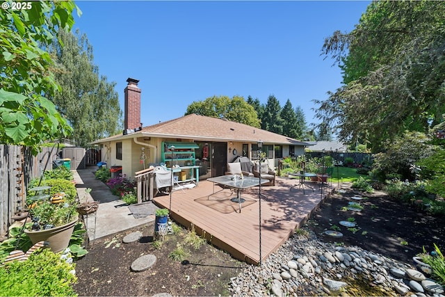 11820 SW Reid Ct, Beaverton, OR 97008 - back of property with a fenced backyard, a chimney, and a deck