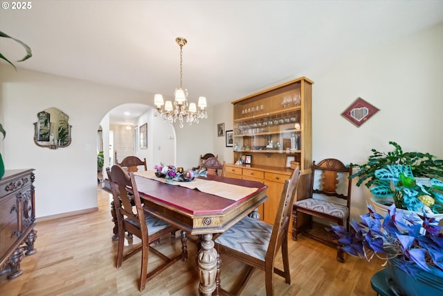 11820 SW Reid Ct, Beaverton, OR 97008 - dining area featuring arched walkways, a chandelier, and light wood-style floors