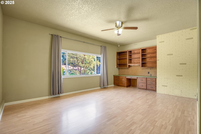 3116 Vista Dr, Forest Grove, OR 97116 - unfurnished office featuring built in study area, a ceiling fan, light wood-style flooring, a textured ceiling, and brick wall