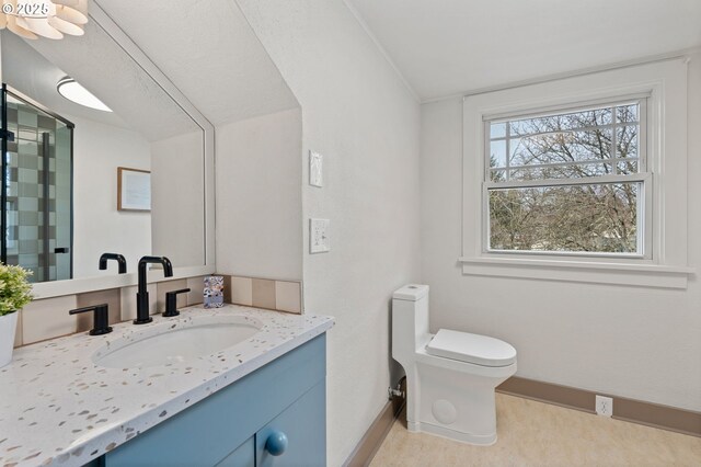 bathroom with vanity, toilet, and baseboards