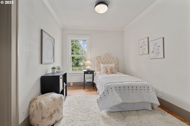 bedroom with baseboards, wood finished floors, and crown molding