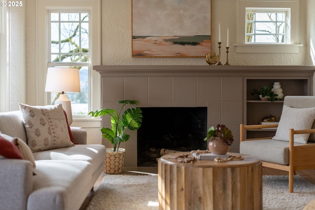 sitting room with a textured wall and a tile fireplace