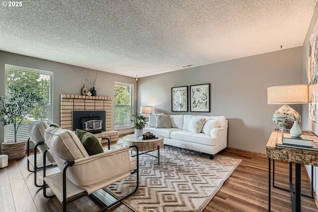 14905 SE Stevenson Dr, Vancouver, WA 98683 - living room with wood finished floors, a brick fireplace, and a textured ceiling