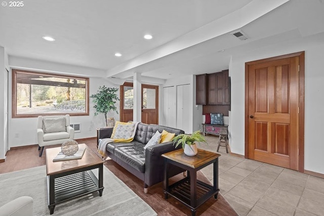 living area with baseboards, visible vents, and recessed lighting