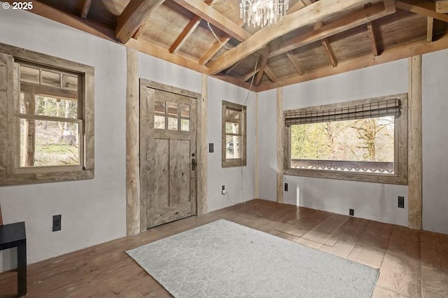 foyer entrance featuring vaulted ceiling, hardwood / wood-style floors, and an inviting chandelier