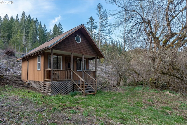 view of front of home featuring a porch and a wooded view