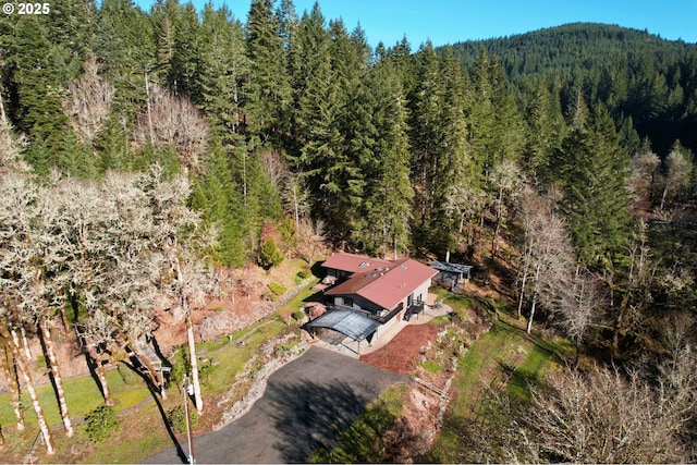 bird's eye view with a wooded view