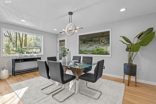 dining area featuring light wood-style flooring, baseboards, a notable chandelier, and recessed lighting