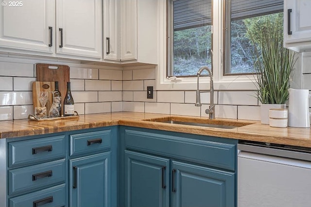 kitchen featuring dishwasher, a sink, white cabinets, and blue cabinets