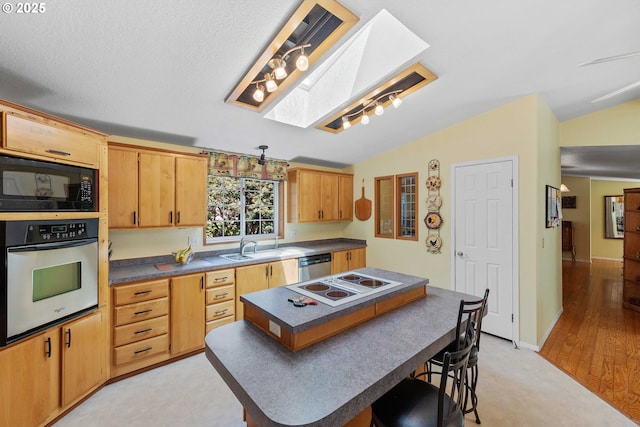 kitchen featuring lofted ceiling, a center island, dark countertops, and appliances with stainless steel finishes