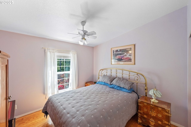 bedroom with baseboards, a ceiling fan, and wood finished floors