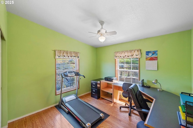 office featuring ceiling fan, a textured ceiling, baseboards, and wood finished floors