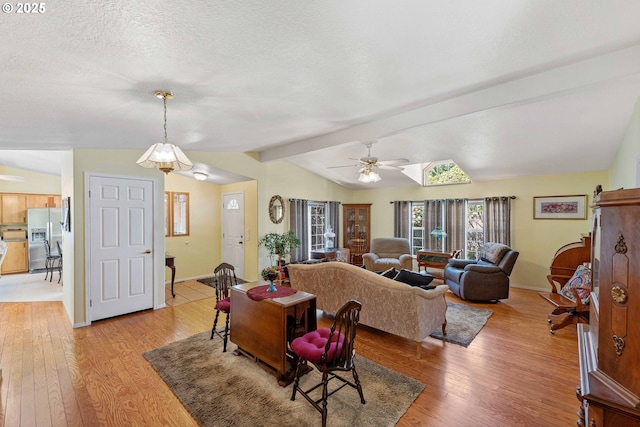 dining room with a ceiling fan, a textured ceiling, baseboards, light wood finished floors, and lofted ceiling with beams