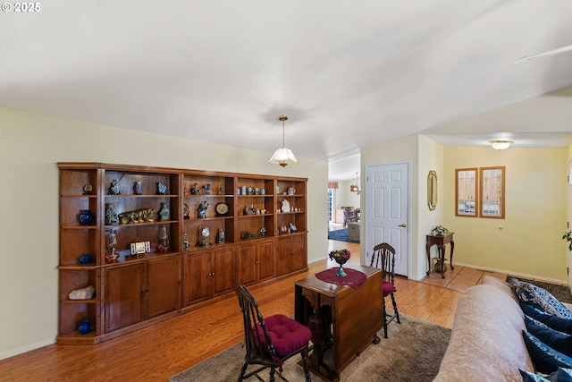 dining space featuring light wood-style flooring and baseboards
