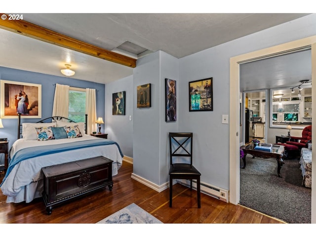 bedroom featuring wood finished floors, baseboards, and a baseboard heating unit