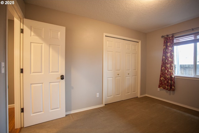 unfurnished bedroom featuring a textured ceiling, a closet, and carpet flooring