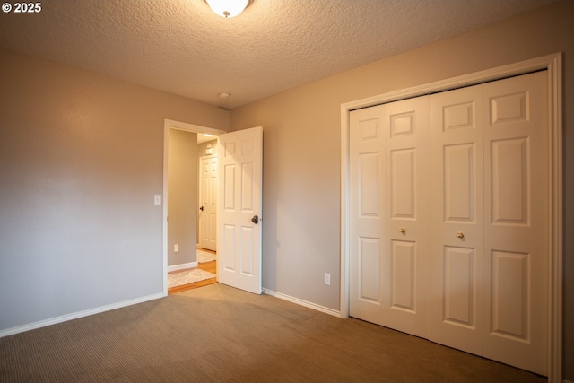 unfurnished bedroom with a textured ceiling, a closet, and carpet floors