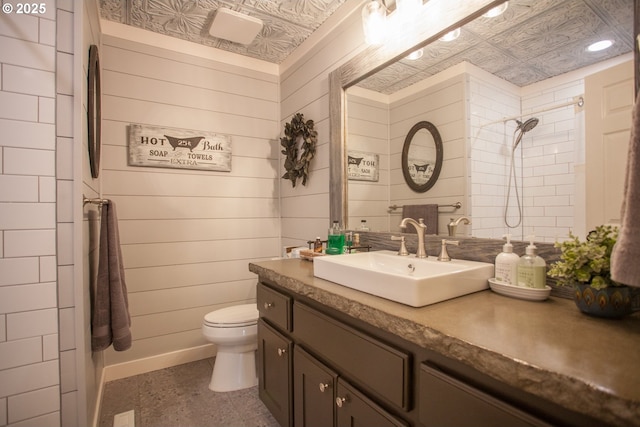 bathroom with walk in shower, wooden walls, vanity, and toilet