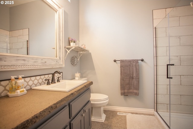 bathroom featuring vanity, walk in shower, and toilet