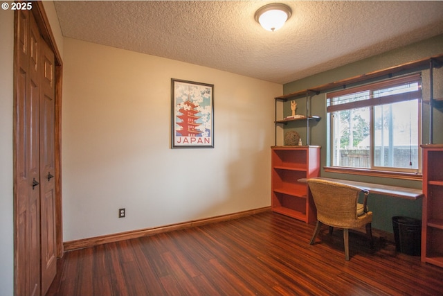 home office with a textured ceiling and dark wood-type flooring