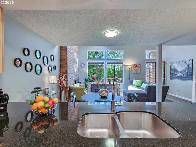 12066 SE 104th Ct Unit 20, Happy Valley, OR 97086 - kitchen featuring open floor plan, a textured ceiling, a brick fireplace, and dark stone counters