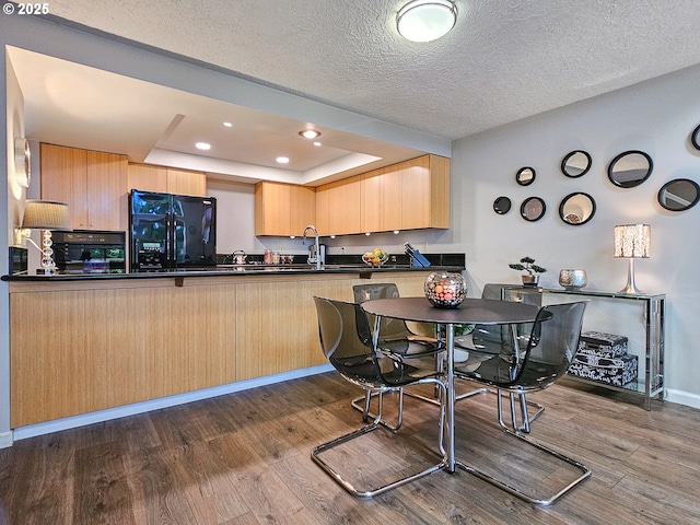 12066 SE 104th Ct Unit 20, Happy Valley, OR 97086 - kitchen with black fridge with ice dispenser, light brown cabinetry, a raised ceiling, dark wood-style flooring, and dark countertops