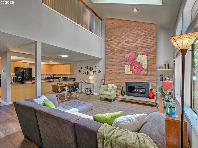 12066 SE 104th Ct Unit 20, Happy Valley, OR 97086 - living area featuring high vaulted ceiling, a brick fireplace, and wood finished floors