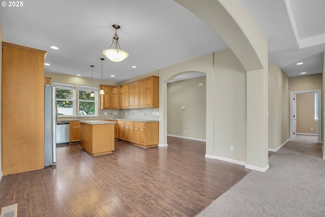 20021 Tharp Ct, Oregon City, OR 97045 - kitchen featuring stainless steel appliances, a center island, light countertops, arched walkways, and dark wood-type flooring