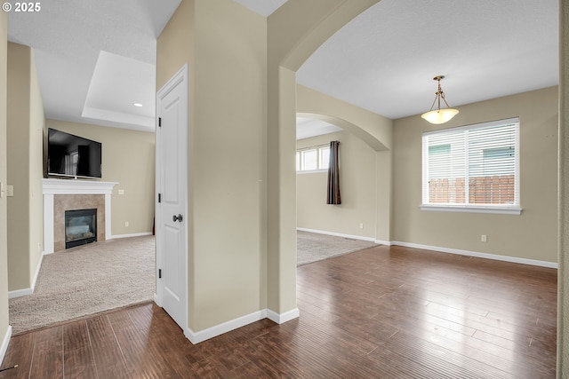 20021 Tharp Ct, Oregon City, OR 97045 - unfurnished living room with arched walkways, dark wood-style floors, and a tiled fireplace