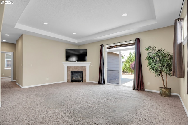 20021 Tharp Ct, Oregon City, OR 97045 - unfurnished living room with a tray ceiling, carpet, a tiled fireplace, and recessed lighting