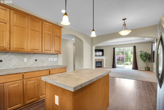20021 Tharp Ct, Oregon City, OR 97045 - kitchen with light countertops, dark wood-style flooring, backsplash, a tiled fireplace, and decorative light fixtures