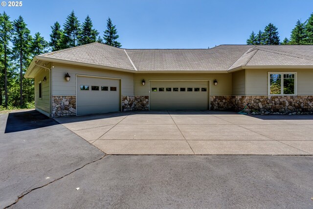 85339 Svarverud Rd, Eugene, OR 97405 - view of front facade featuring stone siding, concrete driveway, a garage, and roof with shingles