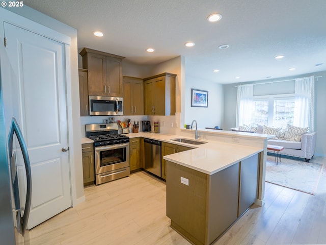 11473 SE Pleasant Valley Pkwy, Happy Valley, OR 97086 - kitchen featuring stainless steel appliances, a sink, a peninsula, light wood-type flooring, and recessed lighting