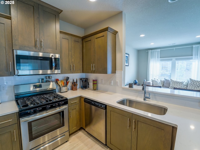 11473 SE Pleasant Valley Pkwy, Happy Valley, OR 97086 - kitchen featuring appliances with stainless steel finishes, a sink, recessed lighting, light countertops, and decorative backsplash