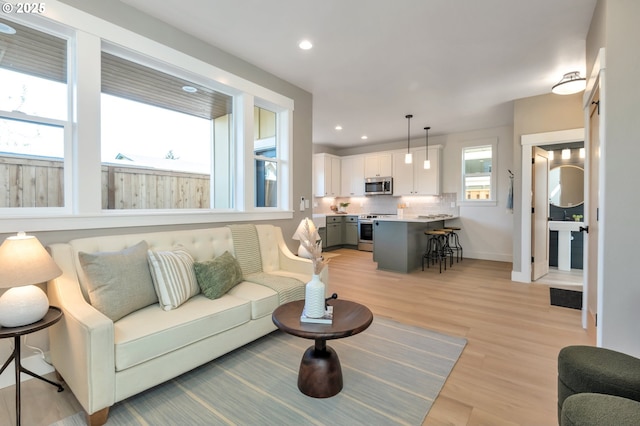 7265 SE Duke St Unit 2, Portland, OR 97206 - living room featuring light wood-style floors, recessed lighting, and baseboards