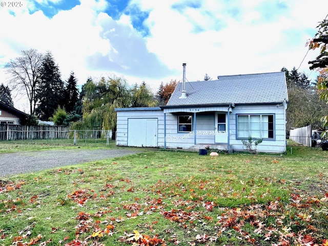 back of house featuring a lawn and fence