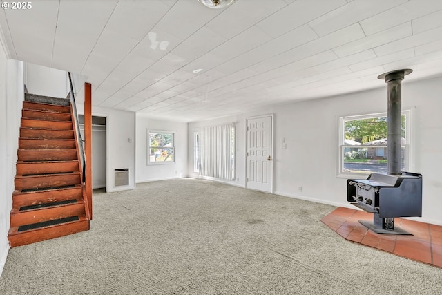 2134 Minnesota St, Eugene, OR 97402 - unfurnished living room with a wood stove, carpet flooring, stairs, and baseboards