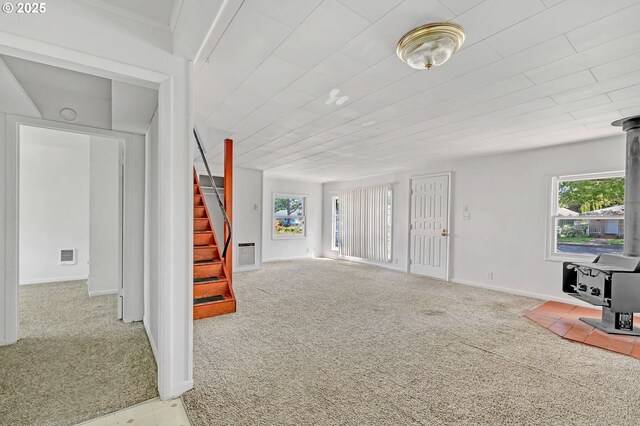 2134 Minnesota St, Eugene, OR 97402 - carpeted living area featuring a wood stove, stairs, and baseboards
