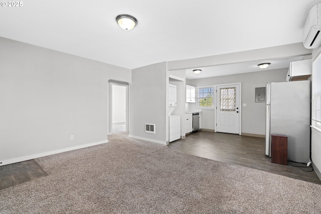 unfurnished living room with a wall mounted AC and dark colored carpet