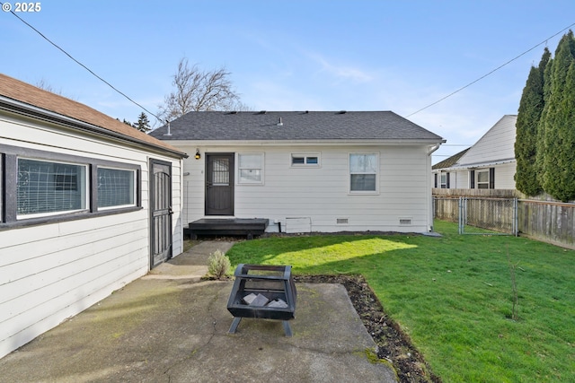 rear view of property featuring a yard, a patio area, and an outdoor fire pit